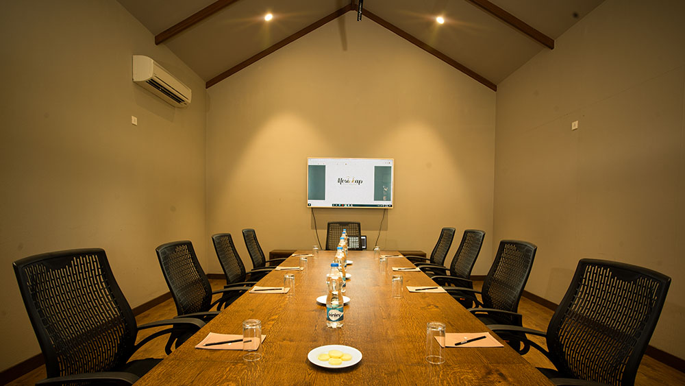 “Boardroom at Morickap Resort, Wayanad – Modern conference space with LED display, seating for executive meetings, and elegant professional setup.”