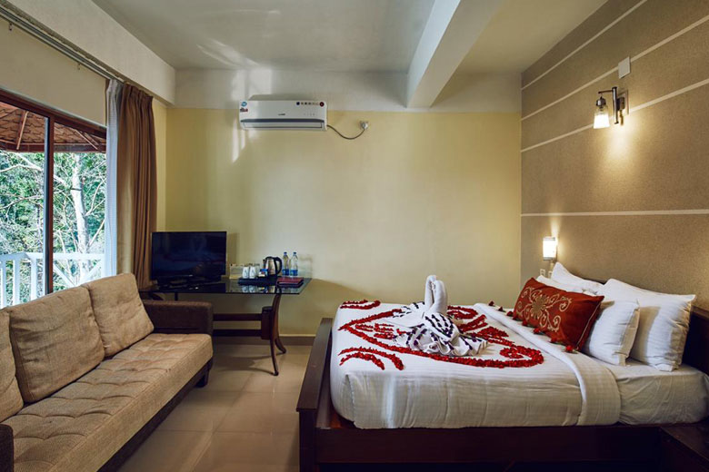 Elegant honeymoon room with beautiful flower arrangements at Southern Panorama Indriya Resorts & Spa in Munnar.