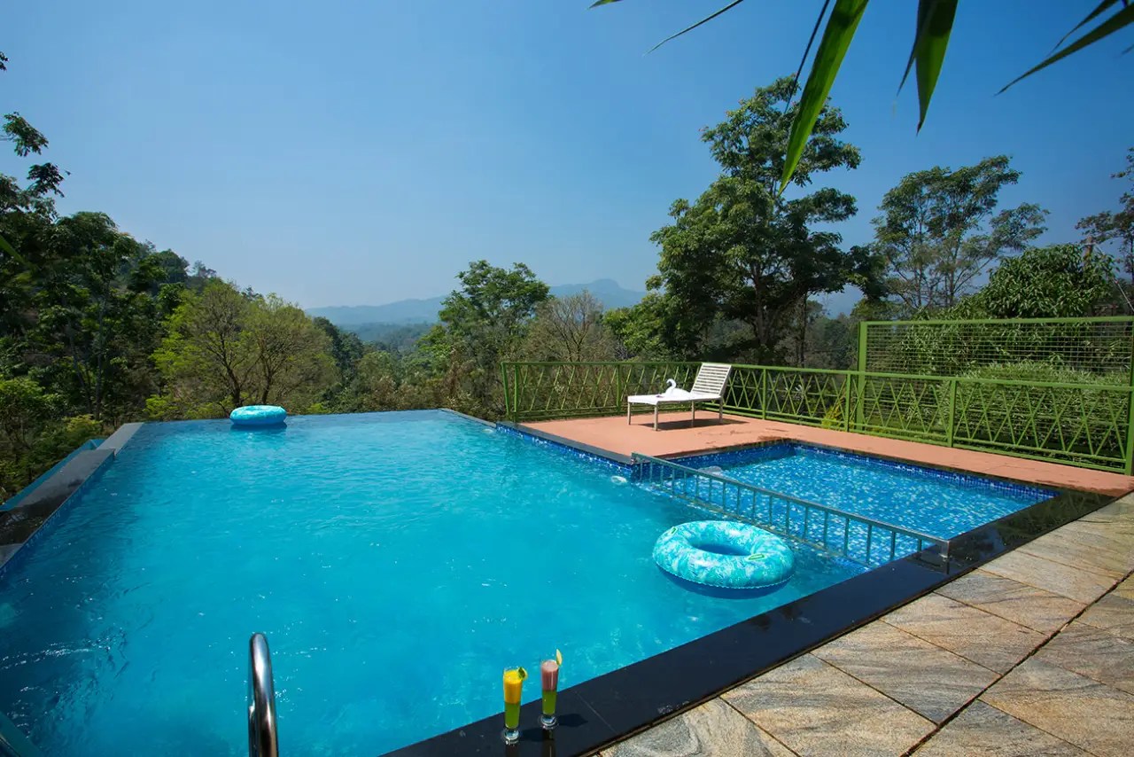 Infinity swimming pool overlooking misty hills at Amrezy Resort & Spa, one of the best Vythiri resorts.