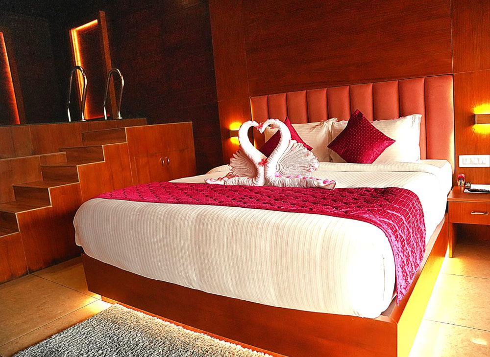 Luxury honeymoon cottage in Munnar with private terrace, cozy interiors, and misty mountain views surrounded by lush greenery.