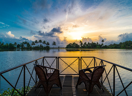 A tranquil lake view at Warmth Lake Haven Island Resort, where the calm waters of Vembanad Lake and glowing sunsets create a perfect backwater escape in Alleppey.