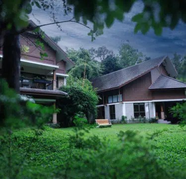 Luxury Wayanad resort surrounded by misty mountains and lush greenery.